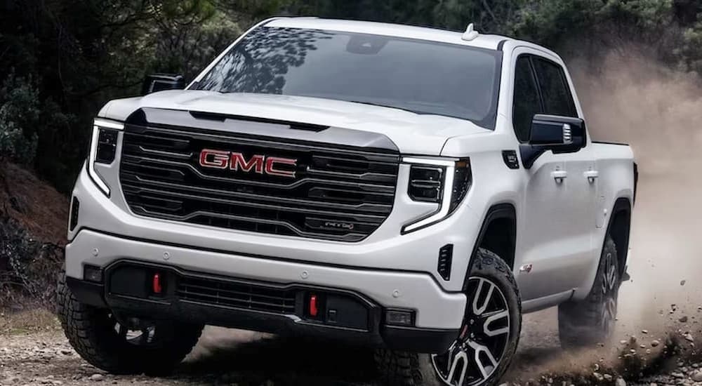 A white 2023 GMC Sierra 1500 AT4 is showing off-roading.