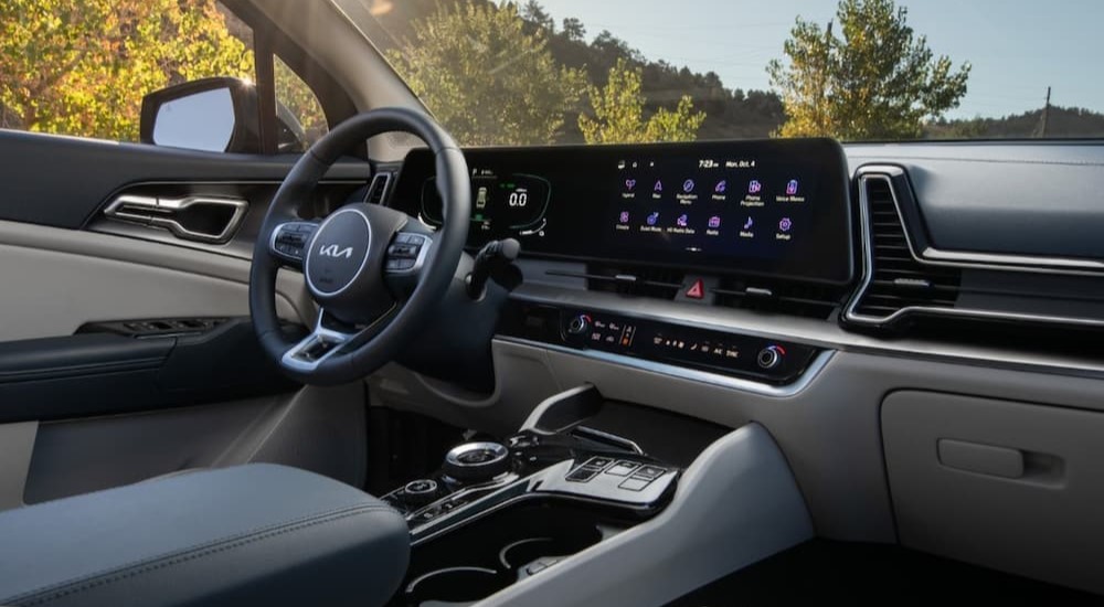 The black and white interior and dash of a 2023 Kia Sportage Hybrid is shown.