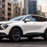 A white 2023 Kia Sportage Hybrid is shown parked near a building.