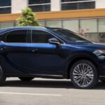 After getting a Lexus RX 350 lease, a blue 2023 Lexus RX 350, is shown driving on a city street.