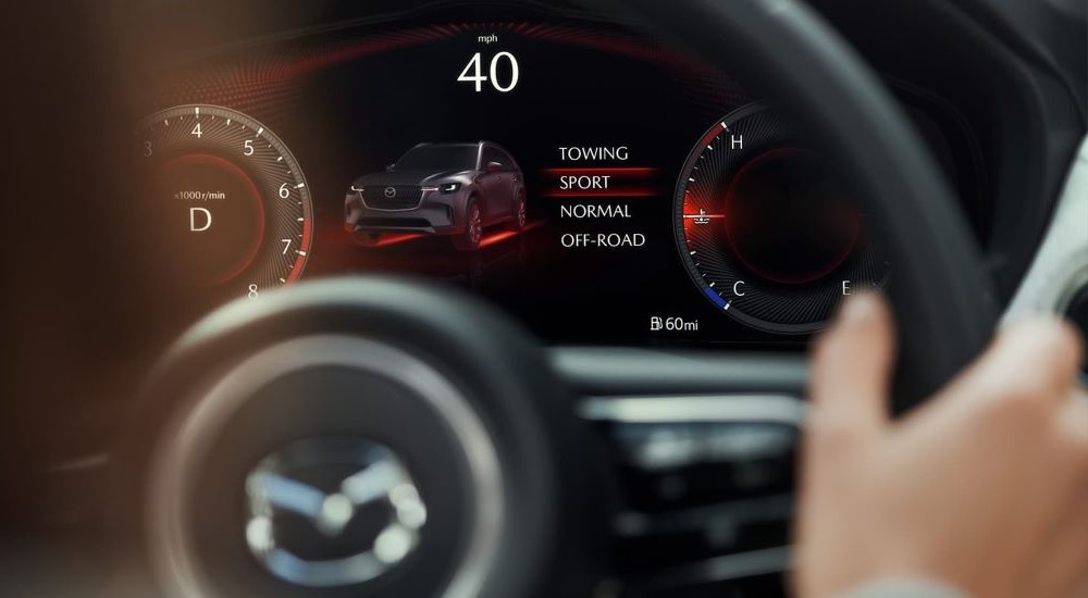 A close up shows sport mode on the gauge in a 2024 Mazda CX-90.