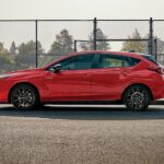 A popular Subaru Impreza for sale, a red 2024 Subaru Impreza, is shown parked on a city street.