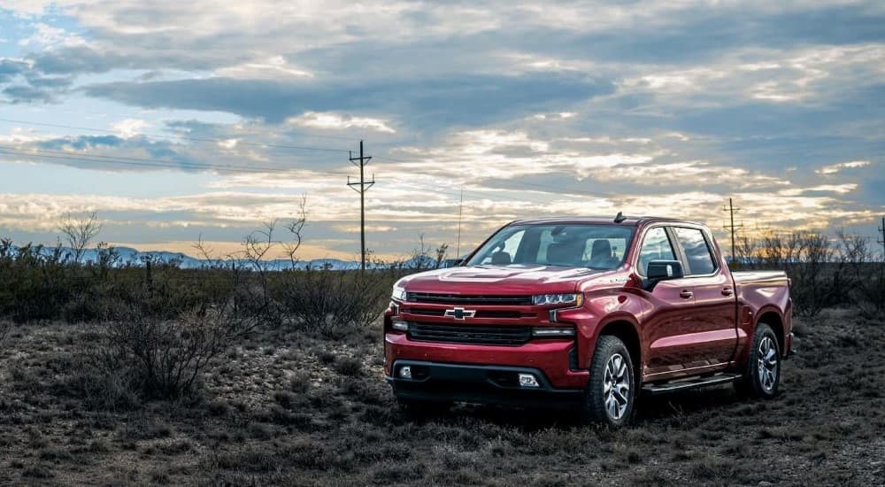 A red 2023 Chevy Silverado RST is shown parked near a field.