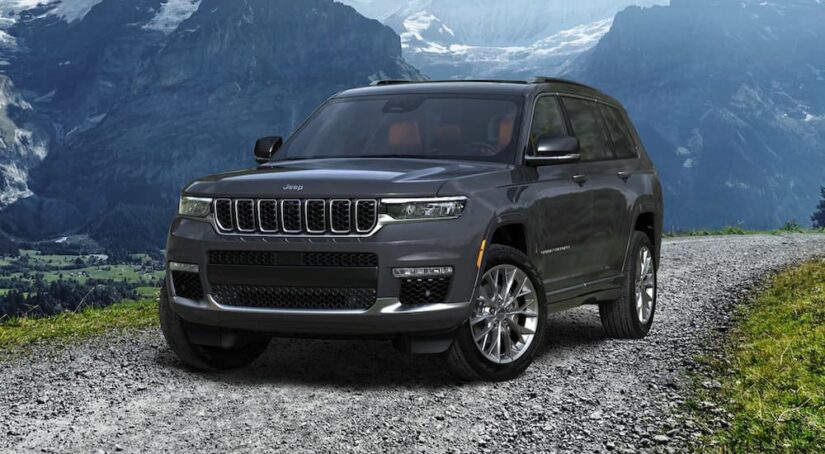 A dark gray 2023 Jeep Grand Cherokee is shown parked near a mountain range.