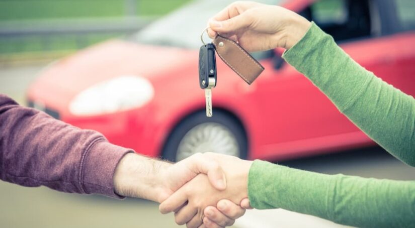 Two people are shown shaking hands and exchanging keys.