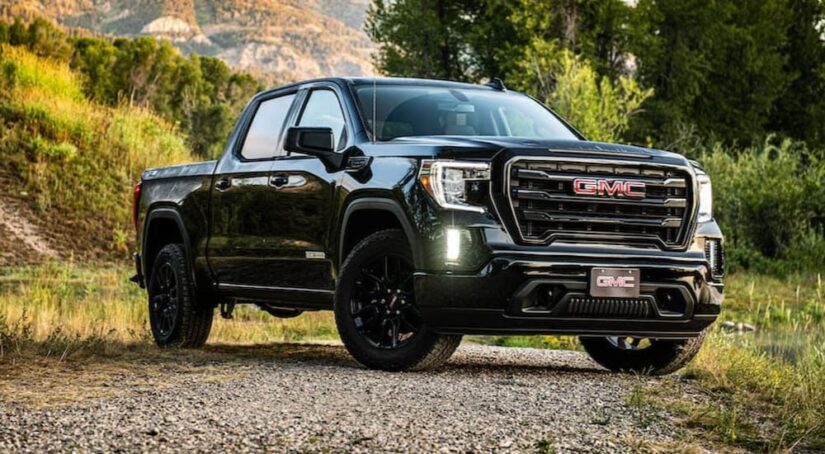 Popular used GMC trucks for a sale, a black 2020 GMC Sierra 1500, is shown parked off-road.