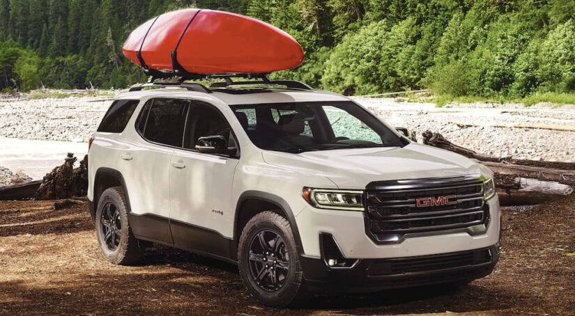 One of the most popular used GMCs, a white 2022 GMC Acadia, is shown parked off-road.