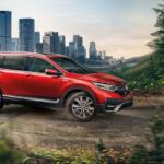 Popular for used SUVs for sale, a red 2020 Honda CR-V, is shown driving off-road.