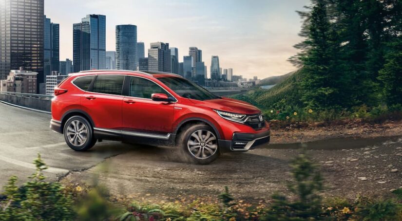 Popular for used SUVs for sale, a red 2020 Honda CR-V, is shown driving off-road.