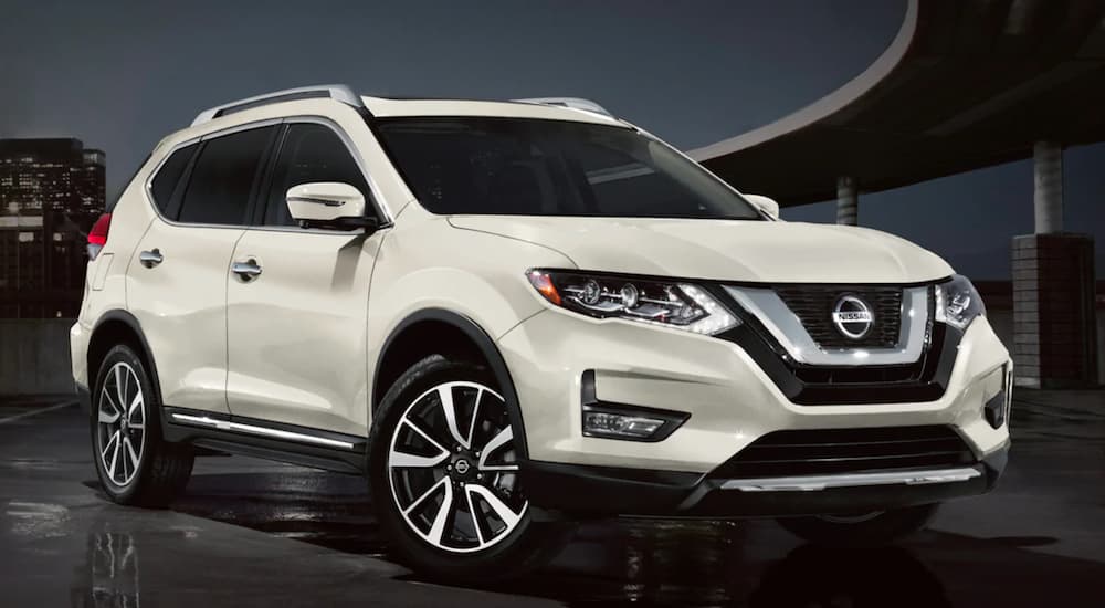A white 2020 Nissan Rogue is shown parked near a city.