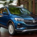 A blue 2023 Buick Encore GX is shown driving on a road after visiting a used Buick dealership.