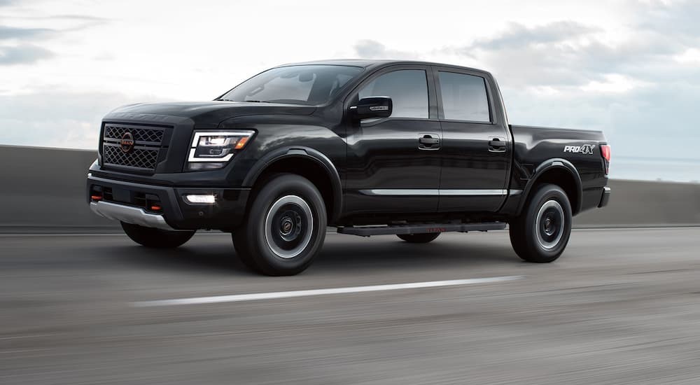A black 2023 Nissan Titan Pro-4X is shown driving on a highway.