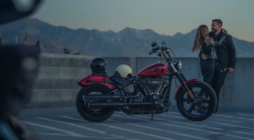 A red 2023 Harley-Davidson Street Bob 114 is shown parked near a couple.