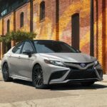 A silver 2023 Toyota Camry XSE is shown parked on a corner.