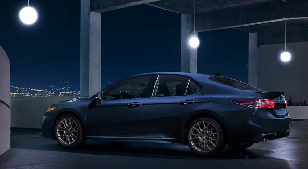 A dark blue 2023 Toyota Camry is shown parked in a parking garage.