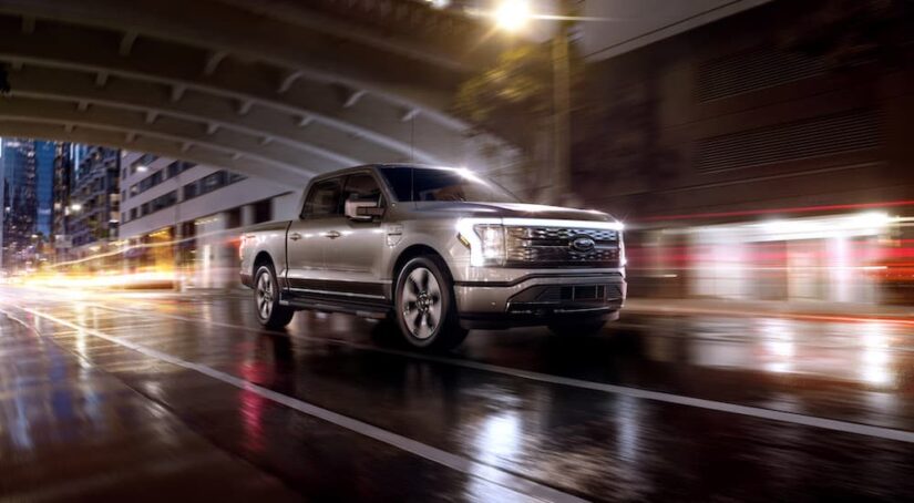 A silver 2023 Ford F-150 Lightning is shown from the front at an angle after leaving a Ford dealer.