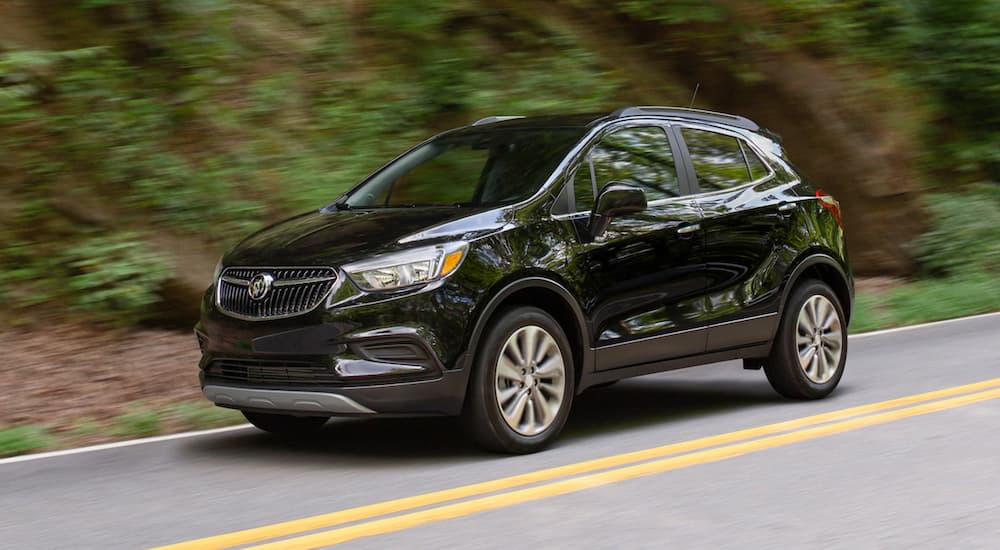 A black 2020 Buick Encore is shown driving on a highway.