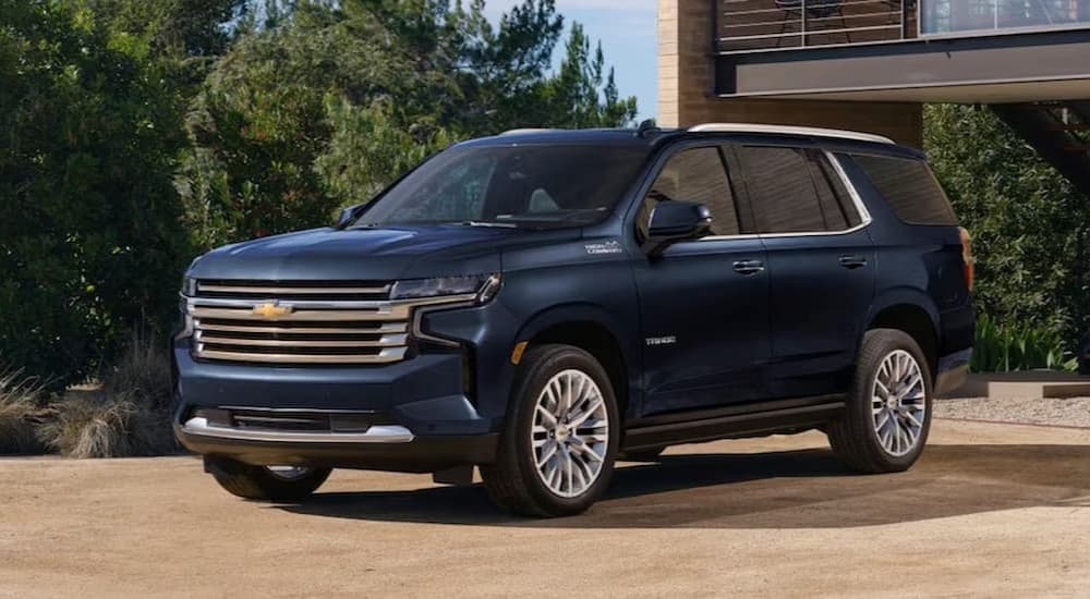A dark blue 2023 Chevy Tahoe is shown parked near a house.