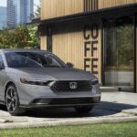 A silver 2023 Honda accord is shown parked near a coffee shop after visiting a Honda dealer.