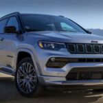 A silver 2023 Jeep Compass is shown parked off-road after visiting a Jeep Compass dealer.
