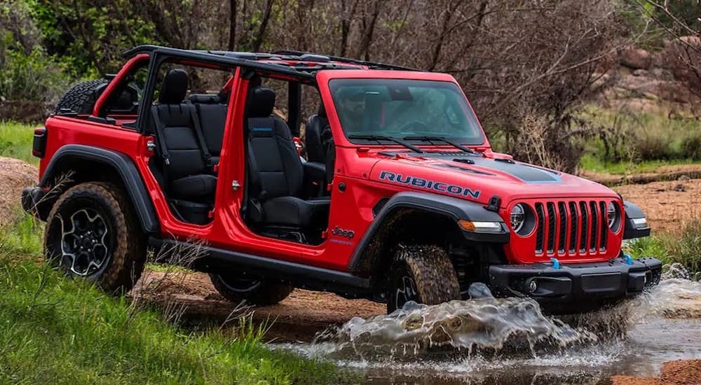 A red 2023 Jeep Wrangler Rubicon is shown from the side after leaving a Jeep dealer.