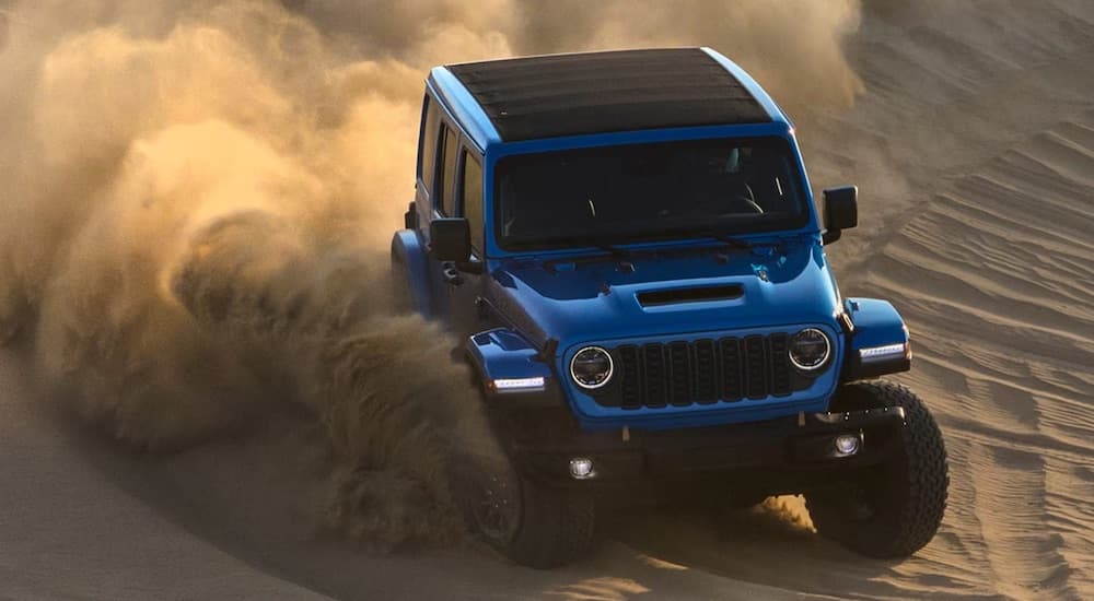 A blue 2024 Jeep Wrangler Rubicon 392 is shown from the front while off-road.