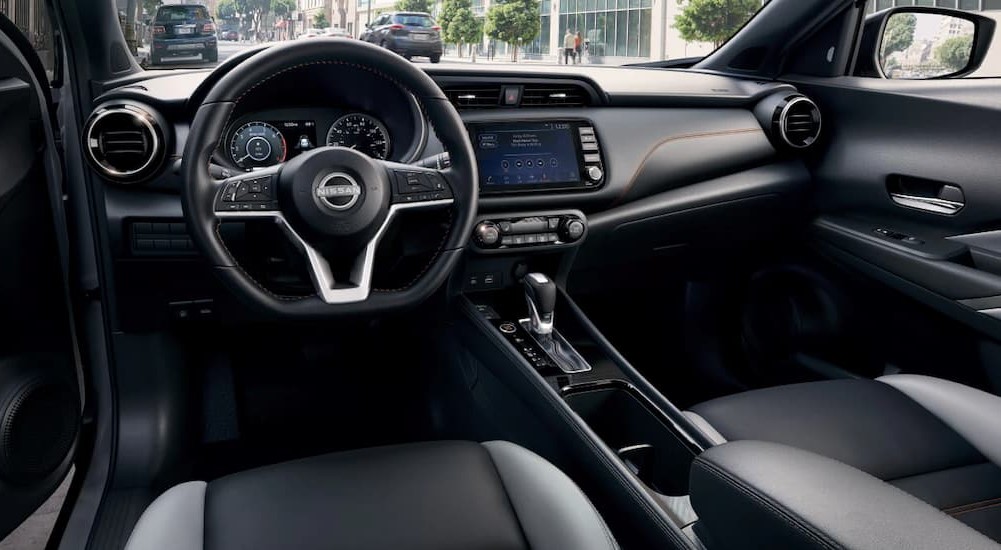 The black and gray interior and dash of a 2023 Nissan Kicks is shown