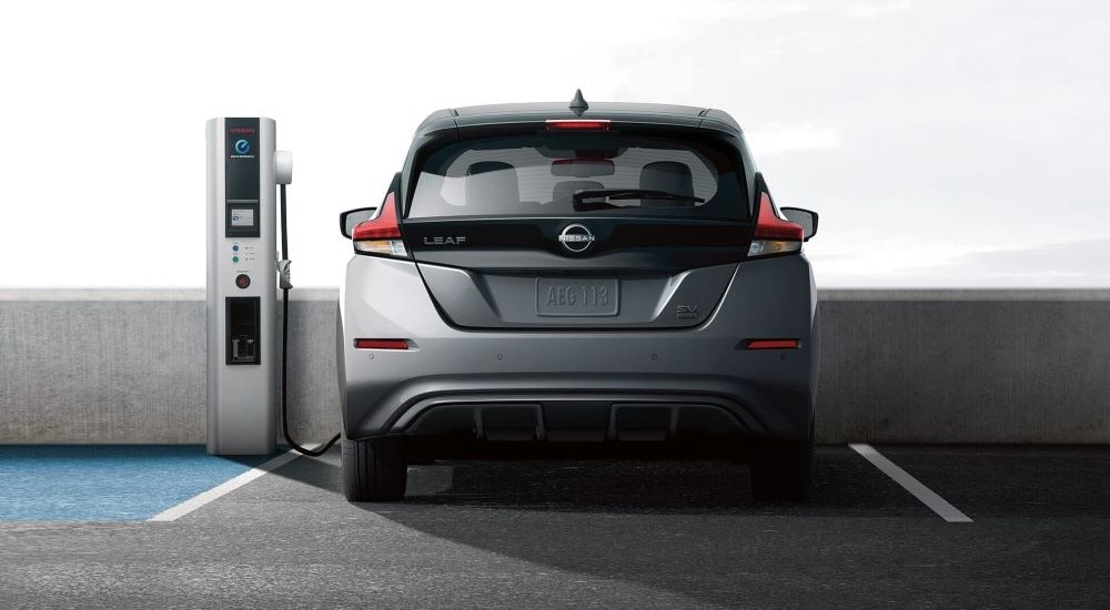 A silver 2023 Nissan LEAF SV is shown from the rear at a charging station.