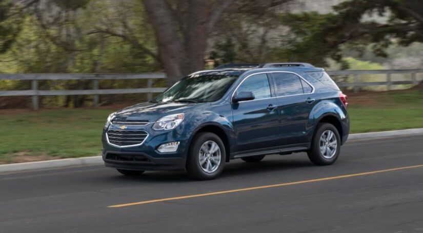 A popular used Chevy Equinox for sale, a blue 2016 Chevy Equinox is shown driving on a road.