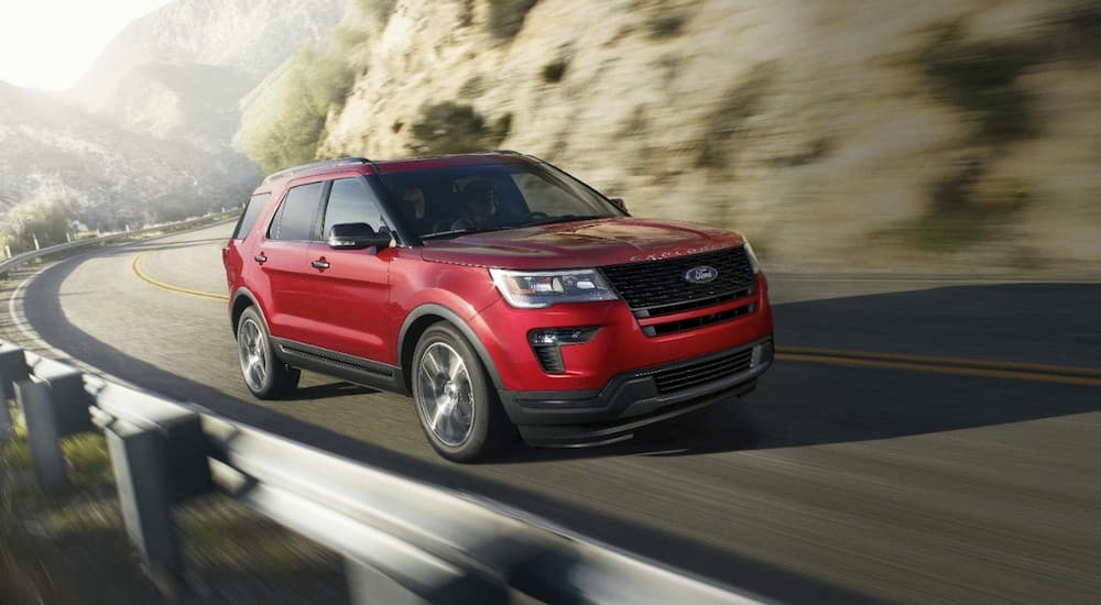 A red 2019 Ford Explorer is shown driving on a highway.