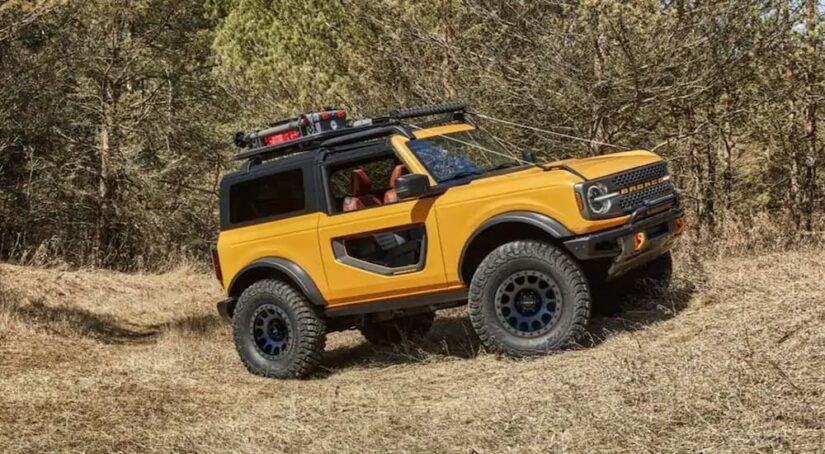 A yellow 2021 Ford Bronco is shown parked off-road after viewing used cars for sale.