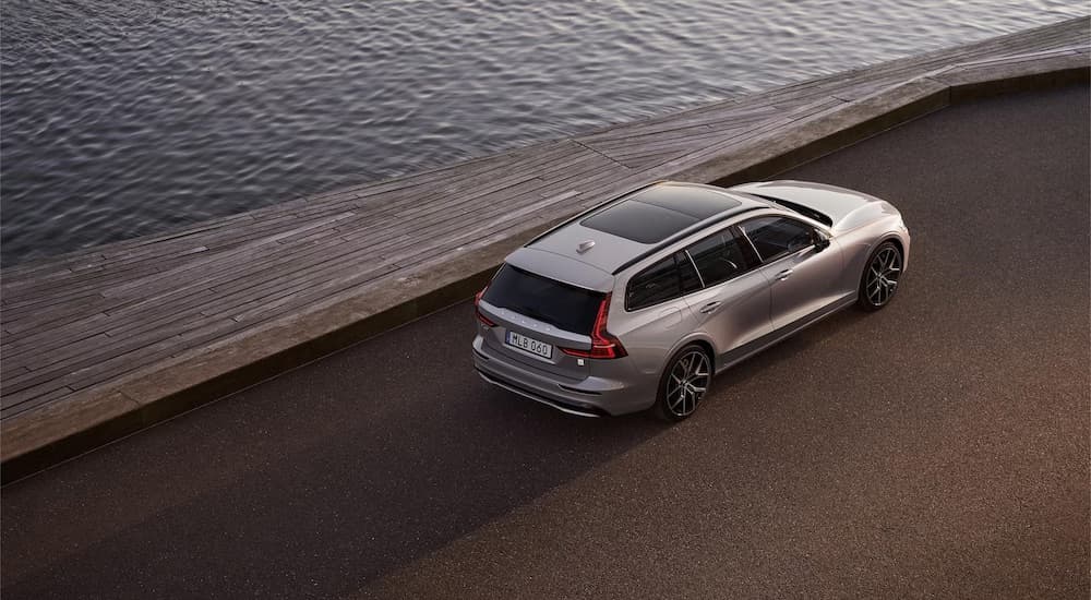 A silver 2023 Volvo V60 Hybrid is shown from the rear at an angle.