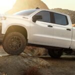 A white 2020 Chevy Silverado 1500 Trail Boss is shown parked off-road after viewing used trucks for sale.