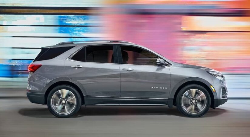 A silver 2023 Chevy Equinox LT is shown driving on a road.