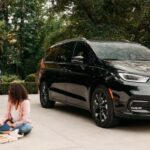 A black 2023 Chrysler Pacifica is shown parked in a driveway after visiting a Chrysler dealer.