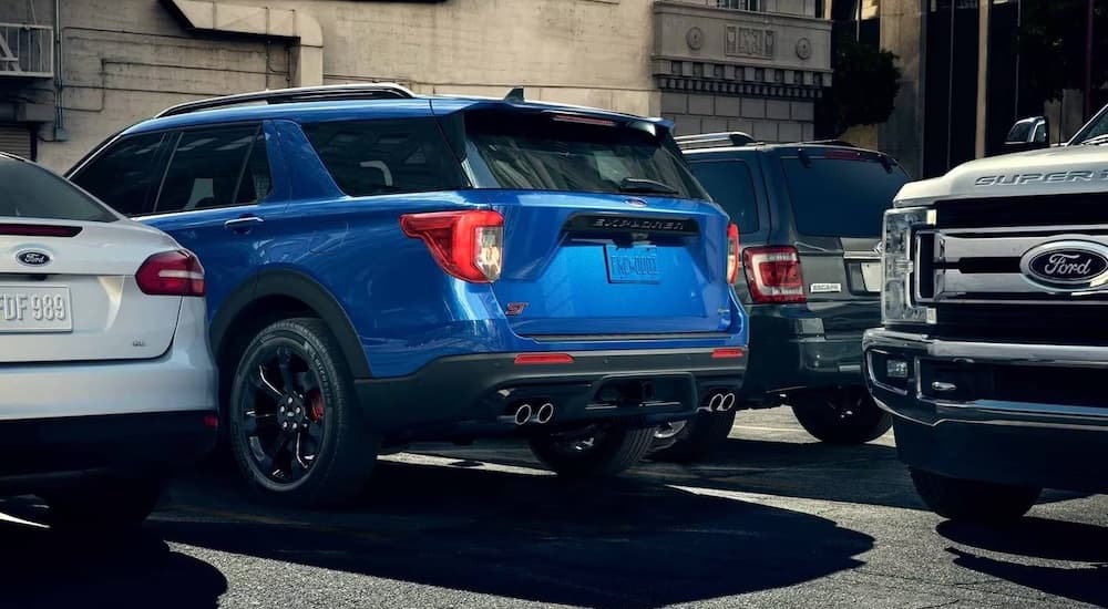 A blue 2023 Ford Explorer XLT is shown from behind parked in a crowded parking lot.