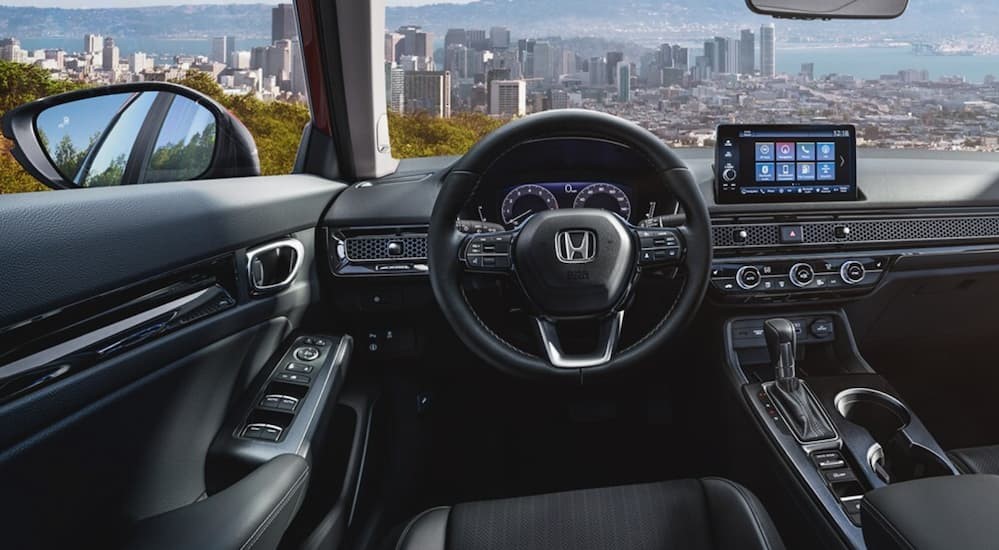 The black interior and dash of a 2023 Honda Civic Sport Touring is shown.