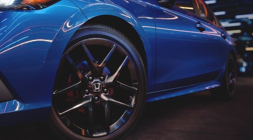 The wheel of a blue 2023 Honda Civic Sport is shown.