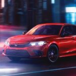 A red 2023 Honda Civic Sport is shown driving on a city street.