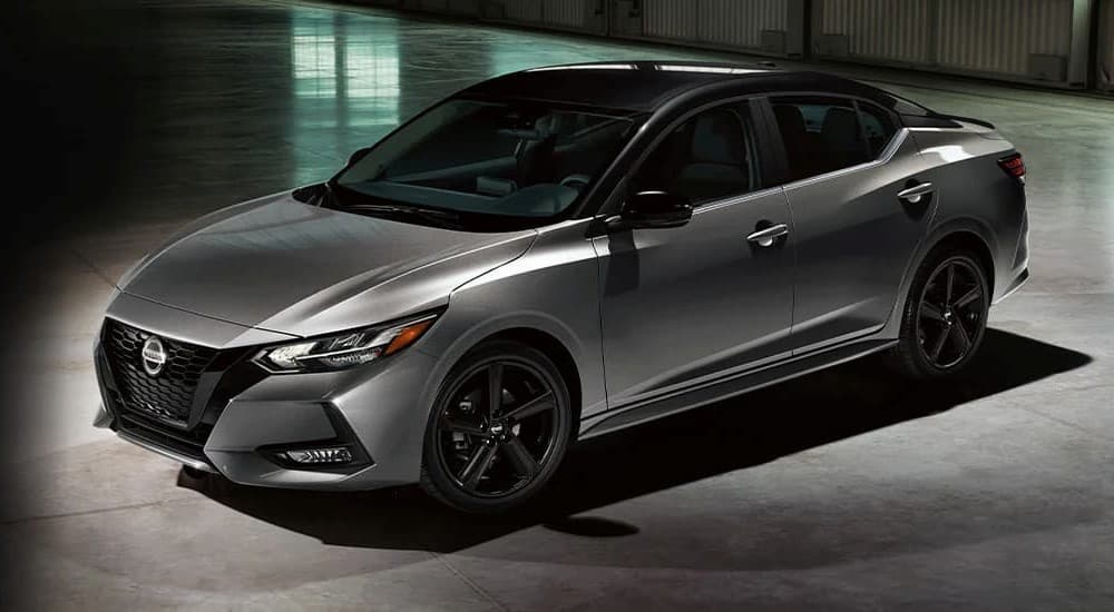 A silver and black 2023 Nissan Sentra Midnight Edition is shown parked in a garage.