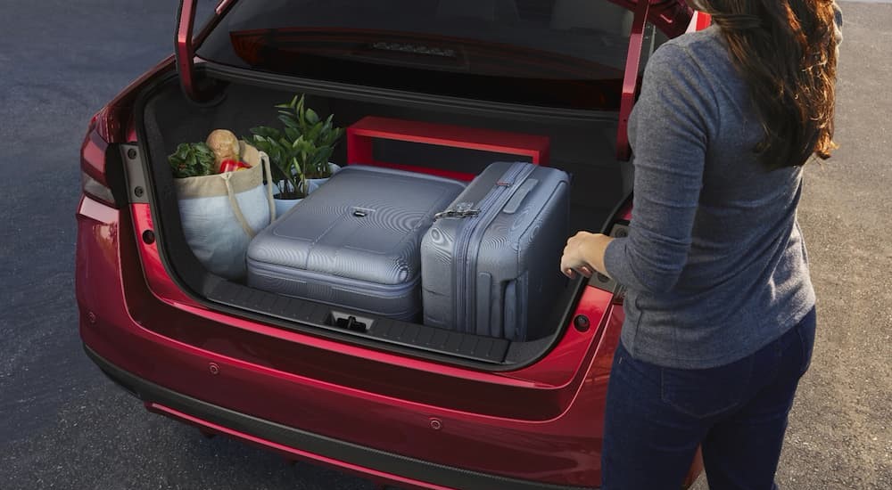 The trunk space of a red 2023 Nissan Versa is shown.