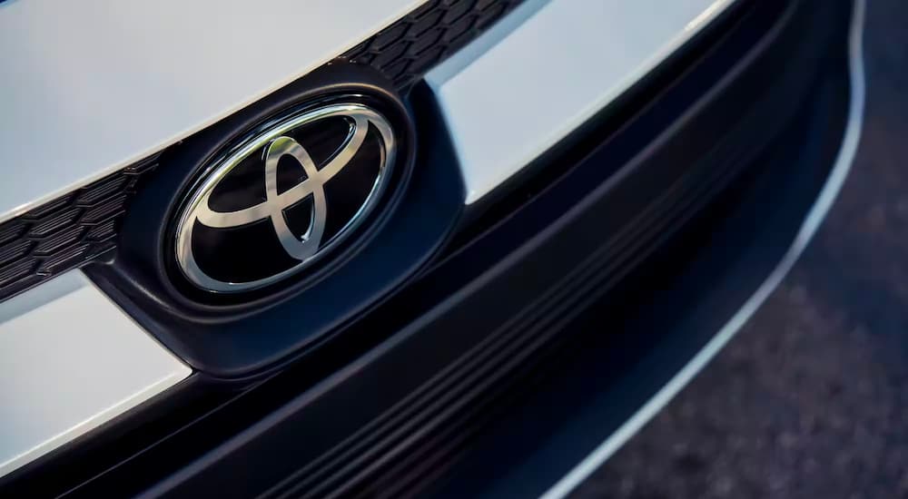 A close-up on the badge of a white 2023 Toyota Corolla LE is shown.