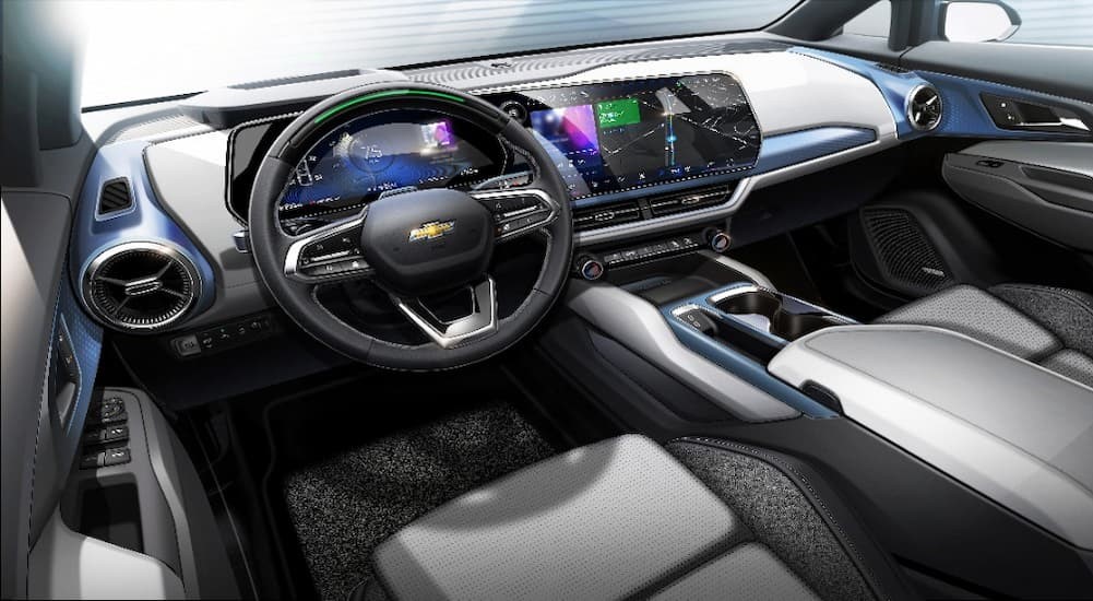 The white, gray and blue interior and dash of a 2024 Chevy Equinox EV is shown.