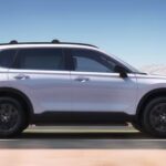 A white 2024 Honda CR-V Sport Touring is shown driving on a highway.