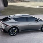 A silver 2023 Kia EV6 GT is shown parked near grass.