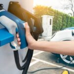 A person is shown preparing to charge an electric car.