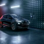 One of the most popular electric cars for sale, a black 2023 Chevy Bolt EUV Redline, is shown driving through a dark tunnel.
