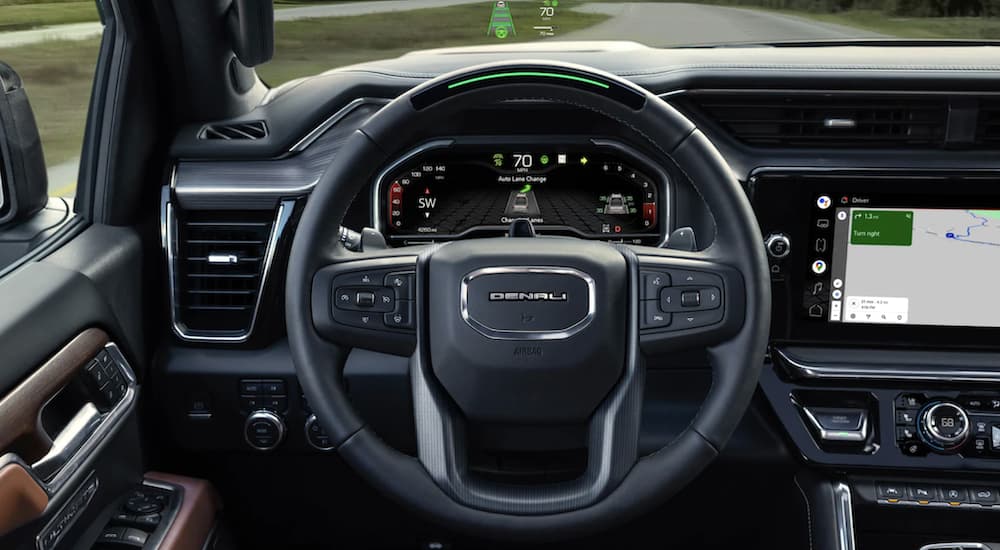 The black interior of a 2023 GMC Sierra 1500 Denali is shown from the front seat.