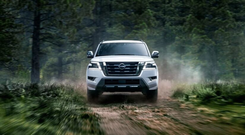 A white 2023 Nissan Armada for sale is shown driving off-road.