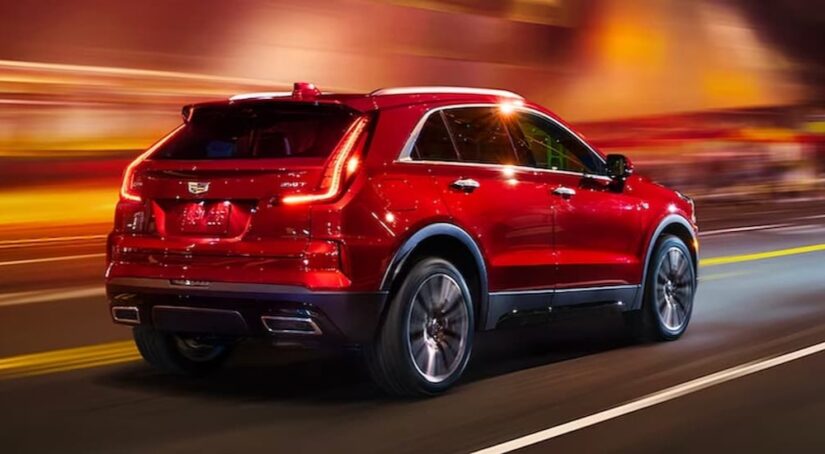 A red 2024 Cadillac XT4 for sale is shown driving on a highway.
